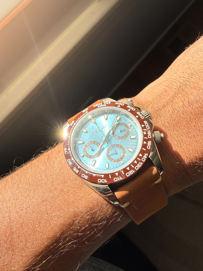 Amber Daytona Homage — dial close-up in direct sunlight, worn on the wrist