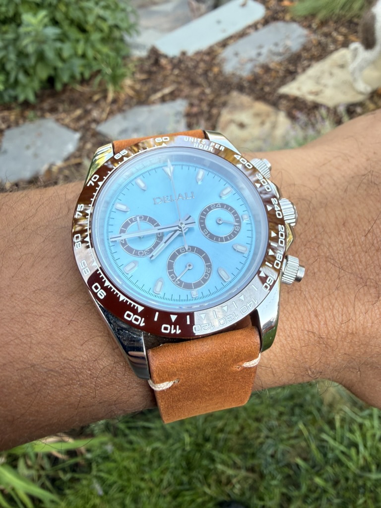 Amber Daytona Homage — worn on the wrist outdoors on a stone path