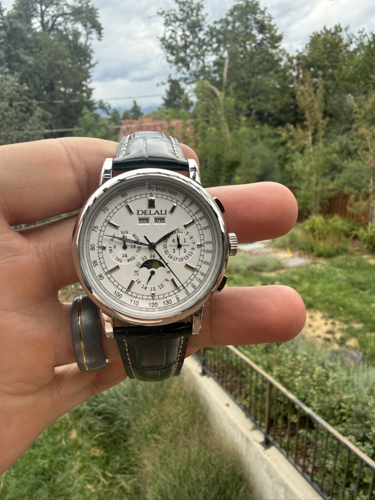 Moonphase Chronograph Homage — held in a hand overlooking a garden