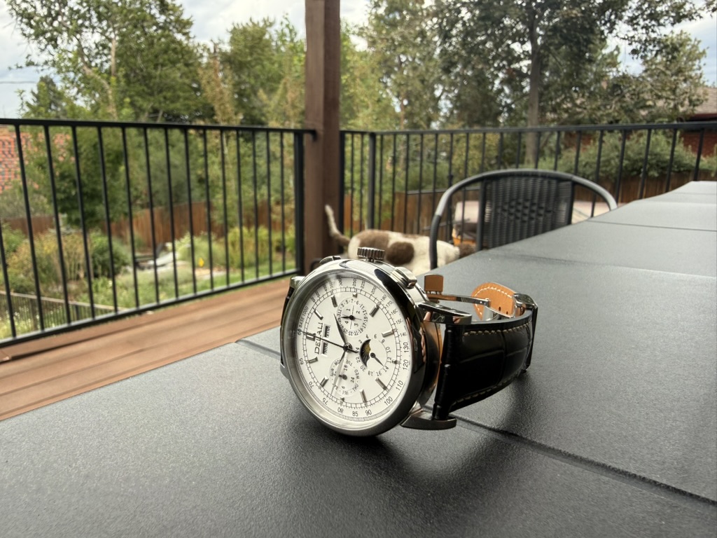 Moonphase Chronograph Homage — resting on an outdoor table with a deck and trees behind it