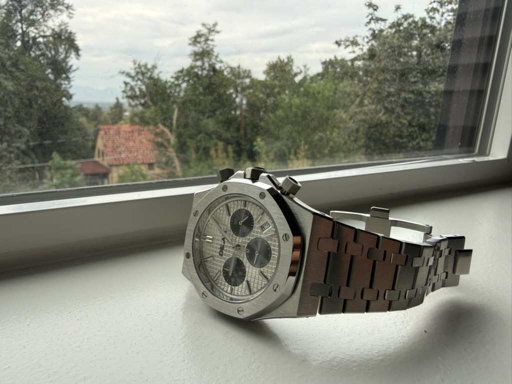 Silver Panda Chronograph Homage — resting on a windowsill overlooking the countryside